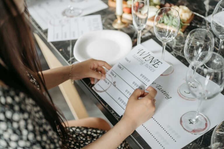 A woman exploring wine tasting notes at an elegantly arranged table in preparation for a wine tasting event.