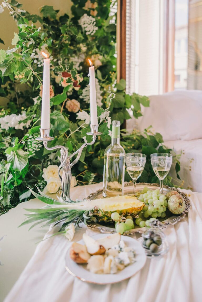 Luxurious setup with wine, fruits, and candles on a decorated table.